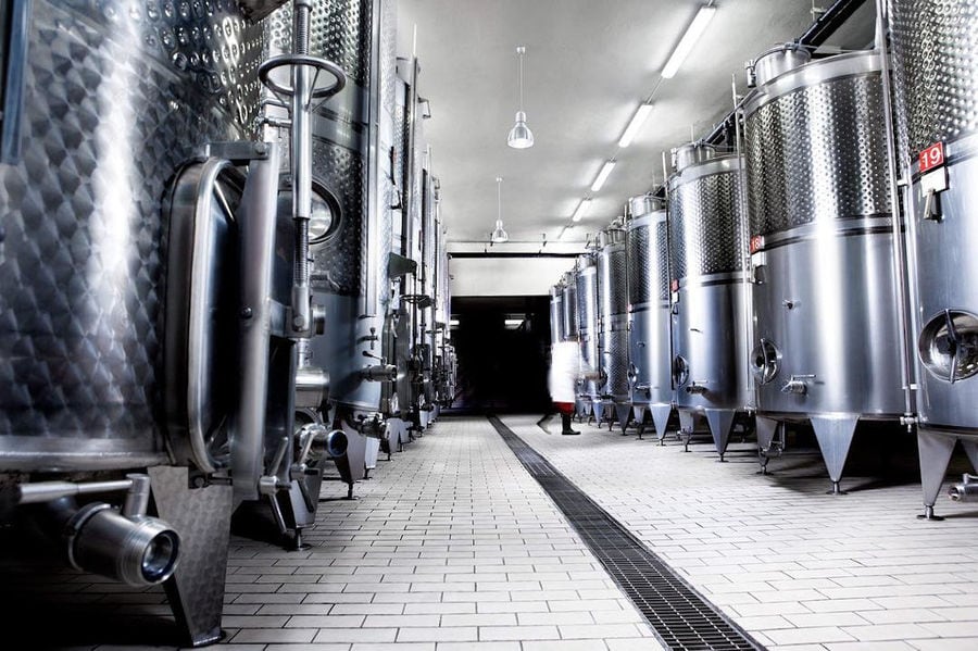 two rows of lying aluminum wine storage tanks at 'Ktima Karipidis' plant